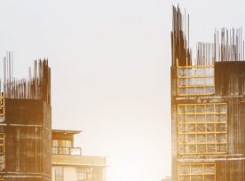 Site Construction In The City With Workers Working In Sunrise