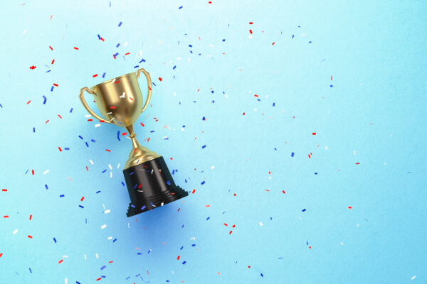 Colorful Confetti Falling Over Gold Cup Sitting Over Blue Background