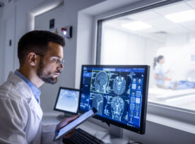 Doctor Examining X Ray Images In Mri Control Room.