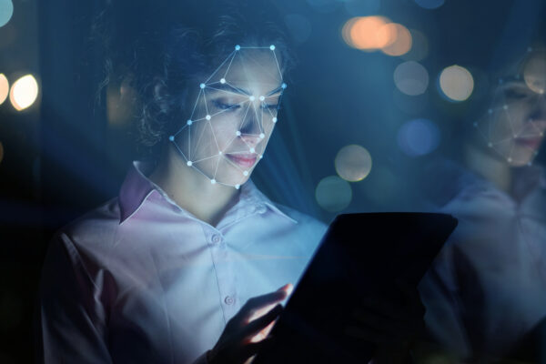 Woman Using Facial Recognition Technology To Access Her Tablet Computer