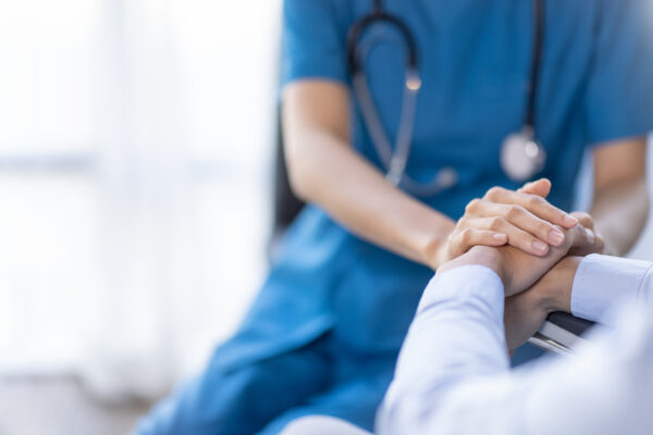 Cropped Shot Of A Female Nurse Hold Her Senior Patient's Hand. Giving Support. Doctor Helping Old Patient With Alzheimer's Disease. Female Carer Holding Hands Of Senior Man