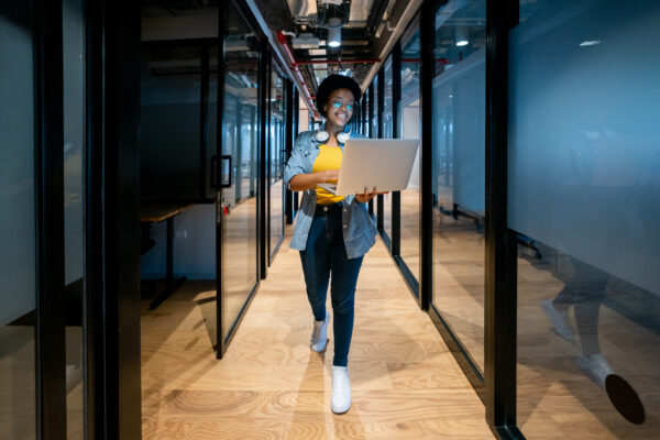 Happy It Technician Working At The Office Using Her Laptop