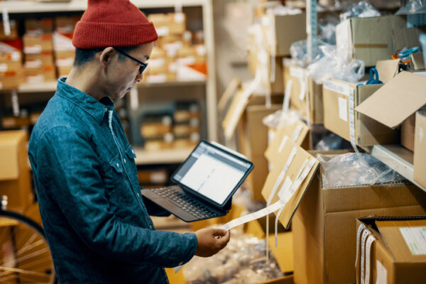 Mid Adult Male Retail Shop Staff Checking Or Looking For Inventory In A Storage Room