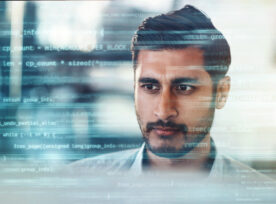 Digitally Enhanced Shot Of A Handsome Businessman Working In The Office Superimposed Over Multiple Lines Of Computer Code