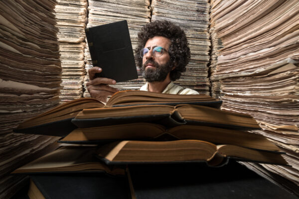 Adult Man With Dark Hair Reading Book In Printed Media Archive