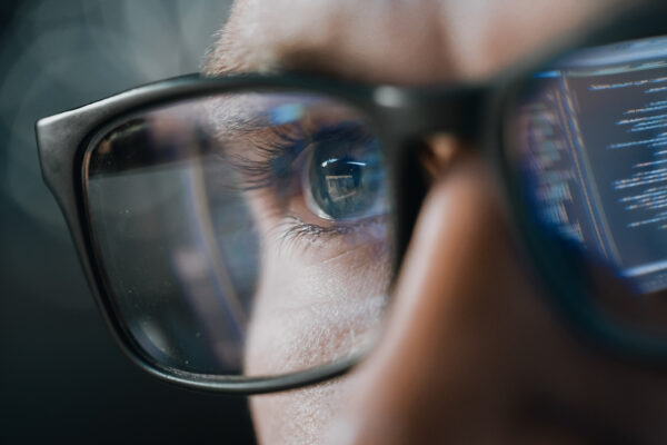Close Up Portrait Of Software Engineer Working On Computer, Line Of Code Reflecting In Glasses. Developer Working On Innovative E Commerce Application Using Machine Learning, Ai Algorithm, Big Data