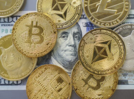 Close Up Shot Of Bitcoin And Alt Coins Cryptocurrency Standing Over A Hundred Dollar Bill. High Angle View, No People