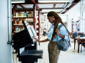 Student Searching For A Book In The Library System