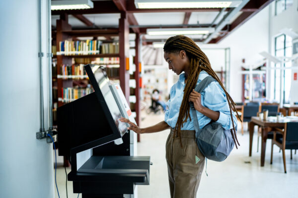 Student Searching For A Book In The Library System