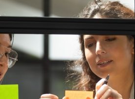 Two women using sticky notes to organize content