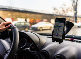 Using Waze Maps Application On Smartphone In Car Dashboard. Driver Using Maps App For Showing The Right Route Through The Traffic In Bucharest, Romania, 2021