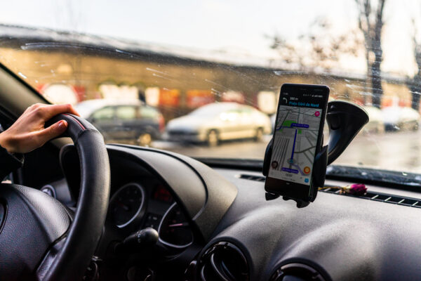 Using Waze Maps Application On Smartphone In Car Dashboard. Driver Using Maps App For Showing The Right Route Through The Traffic In Bucharest, Romania, 2021