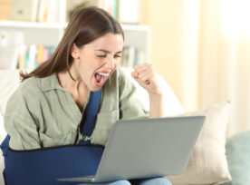 Excited Disabled Woman With Broken Arm Using Accessible Website On Laptop