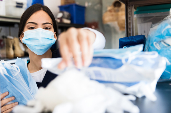 Nurse Reaches For Supplies In Clinic Supply Room