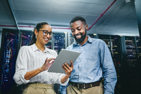 Shot Of Two Young Technicians Using A Digital Tablet While Working In A Server Room