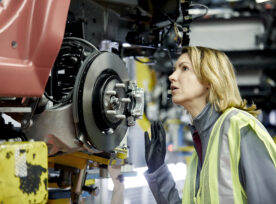 Blond Female Engineer Checking Vehicle At Factory
