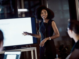 Black woman presenting slides at a meeting
