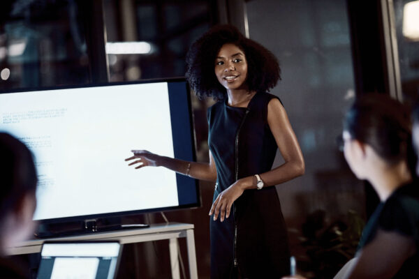 Black woman presenting slides at a meeting