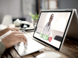 Male Doctor Video Chatting On Laptop