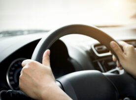 A Woman's Hand Holding A Car Steering Wheel,represents The Correct Car Steering Wheel. In Order To Prevent Accidents. Show Driving Safe Step.