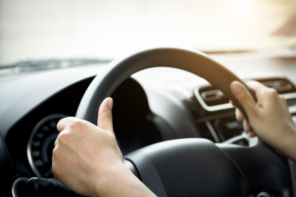 A Woman's Hand Holding A Car Steering Wheel,represents The Correct Car Steering Wheel. In Order To Prevent Accidents. Show Driving Safe Step.