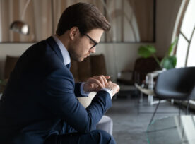 Male Employee Looking At Wristwatch Waiting For Job Interview Time