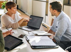 Female Executive Showing Data To Team In Meeting