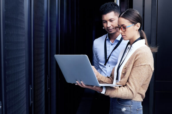 Shot Of Two Technicians Working Together In A Server Room