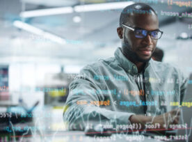 Modern Office: Portrait Of Motivated Black It Programmer Working On Laptop Computer. Male Specialist Create Website, Software Engineer Develop Programme. Shot With Visual Effects Of Running Code.