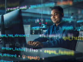 Man working on a computer with lines of code superimposed over him.