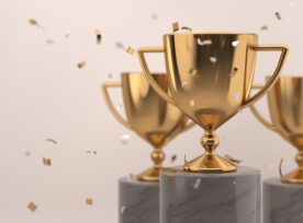 Golden Trophy Award With Falling Confetti On Grey Background. Copy Space For Text. Competition Winner Prize. 3d Rendering.