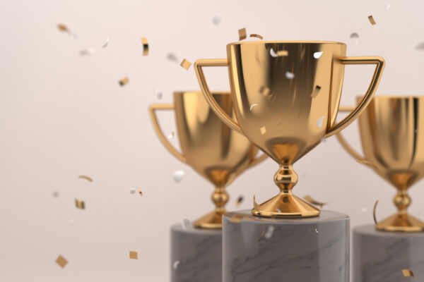 Golden Trophy Award With Falling Confetti On Grey Background. Copy Space For Text. Competition Winner Prize. 3d Rendering.
