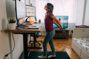 Woman At Home Office Is Walking On Under Desk Treadmill staying active