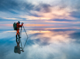Photographer Traveler Taking Photo Of The Beautiful Lake At Sunset.