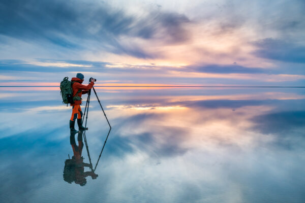 Photographer Traveler Taking Photo Of The Beautiful Lake At Sunset.