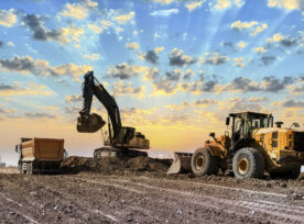 Excavators Working On Construction Site At Sunset