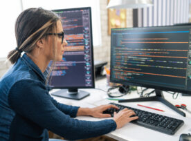 Female Freelance Developer Coding And Programming. Coding On Two With Screens With Code Language And Application.