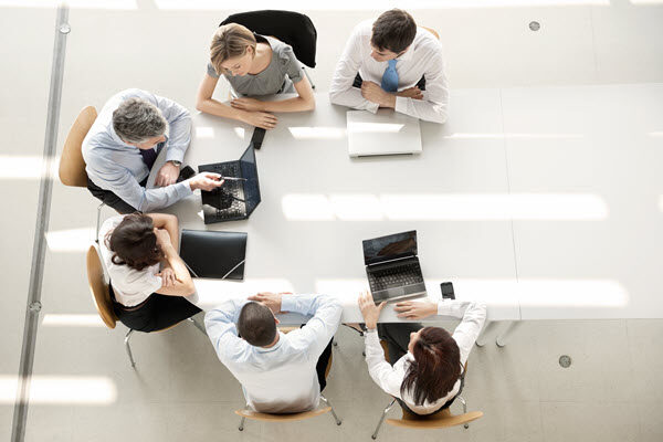 A group of professionals sitting at a table having a meeting.