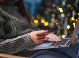 Christmas Online Shopping, Sales And Discounts Promotions During Winter Holidays, Online Shopping At Home. Female Hands On The Laptop With Credit Card And Blurred Bokeh Lights