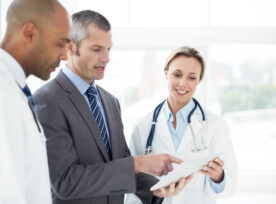 Doctors discussing a tablet with a hospital administrator