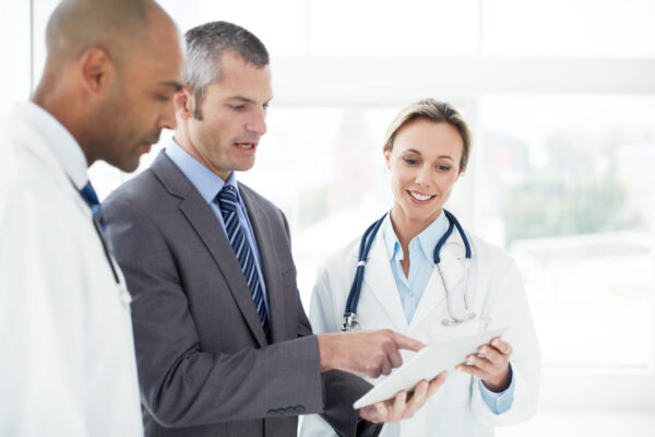 Doctors discussing a tablet with a hospital administrator