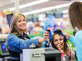 Mother Paying For Groceries With Smart Phone App In Store