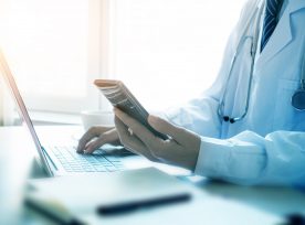 Doctor Using Smartphone In Office