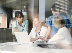 Female Doctors Discussing At Laptop Desk