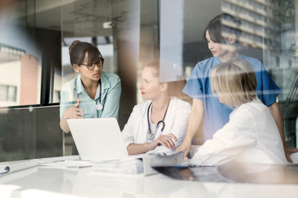 Female Doctors Discussing At Laptop Desk