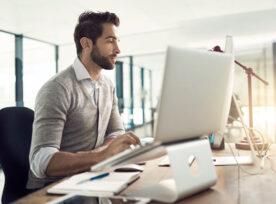 Man on mounted desktop computer working.