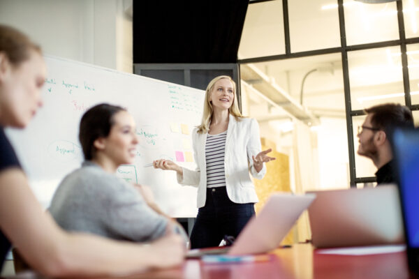 Businesswoman Giving Presentation On Future Plans To Colleagues