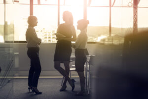 Businesswomen Discussing In Meeting Against Window