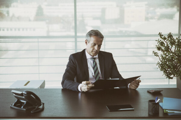 Businessman In His Office Reading A Contract