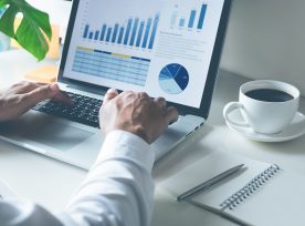 Young Businessman Typing Computer Laptop With Graph Chart